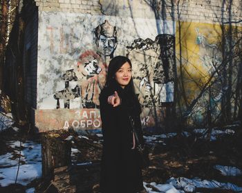 Portrait of woman standing against trees