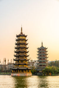 View of temple by building against clear sky