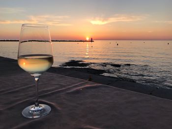 Beer in sea against sky during sunset