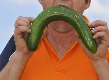 Midsection of man holding vegetables