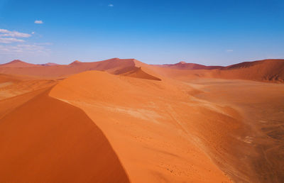 Sand dunes in desert against sky