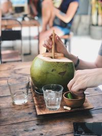 Close-up of hand holding drink on table