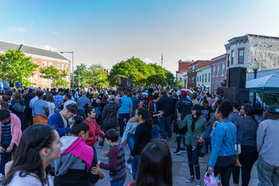 Crowd in city against sky