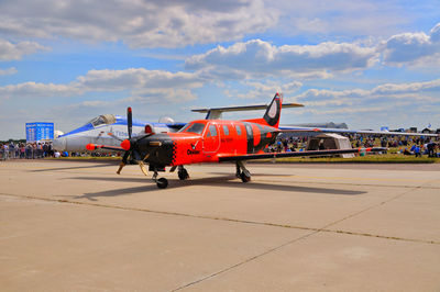 Airplane on airport runway against sky