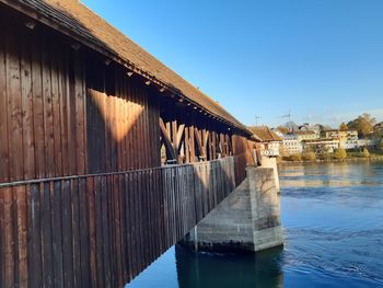 Bridge over river against clear blue sky
