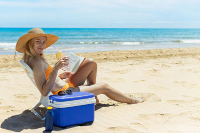 Portrait of woman sitting at beach