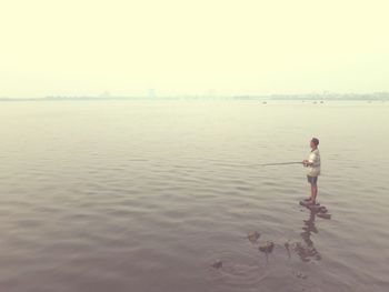 Full length of woman standing by pond