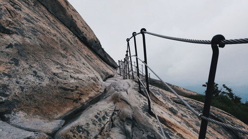 Bridge over mountain against sky