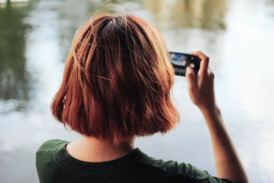 Rear view of woman photographing