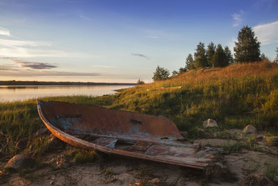 Abandoned boat on shore against sky