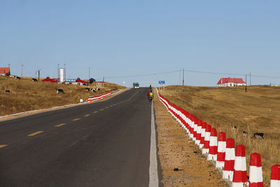 A straight and flat asphalt road leads to the front