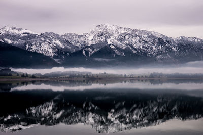 Scenic view of lake and snowcapped mountains against sky