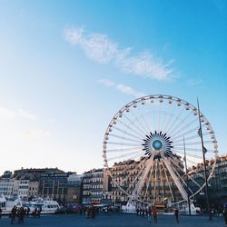 Ferris wheel by buildings against sky