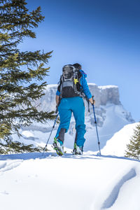 Man skiing on snowcapped mountain against sky