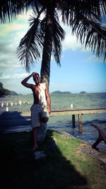 Full length of woman standing on beach against sky