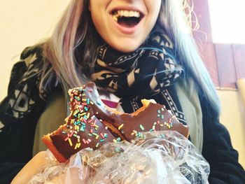 Midsection of woman eating donut