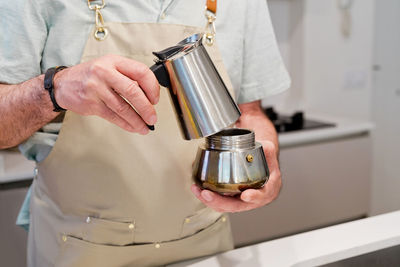 Midsection of man working in kitchen