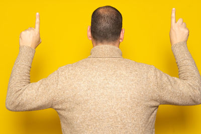 Rear view of man against blue background