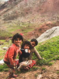 Happy siblings playing on the stone wall