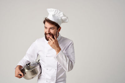 Young man holding ice cream against white background