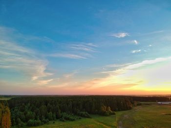 Scenic view of agricultural field against sky during sunset