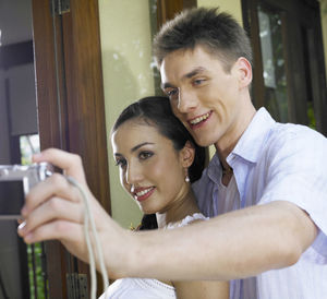 Close-up of couple taking selfie through camera
