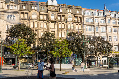 People on street against buildings in city