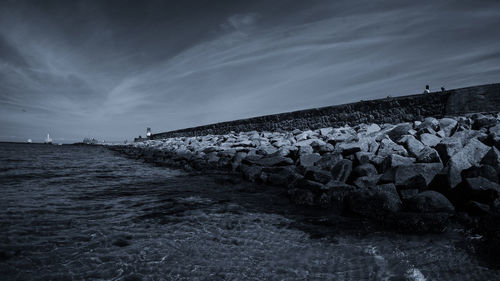 Surface level of rocks on beach against sky