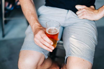 Midsection of man drinking beer glass