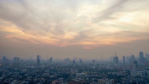 Aerial view of city against sky during sunset