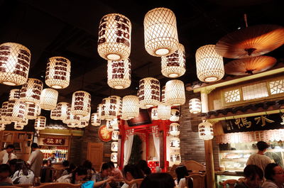 Group of people at illuminated lanterns at night