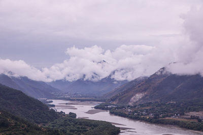 Scenic view of river and mountains against sky