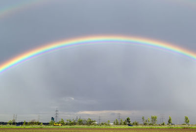 Rainbow over field against sky