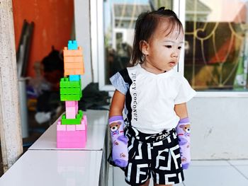 Baby girl looking away while standing at home