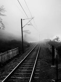 Railroad tracks amidst trees against sky