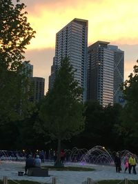 Skyscrapers in city against sky at dusk