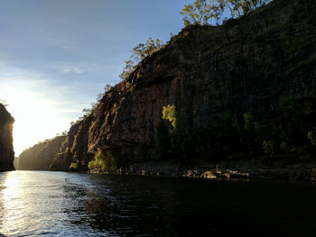 Scenic view of cliff by sea against sky