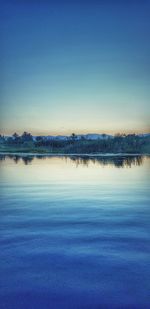 Scenic view of lake against clear blue sky