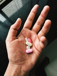 High angle view of person hand holding pills