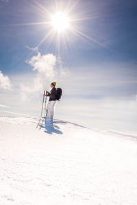 Low angle view of man standing on snow covered land against sky