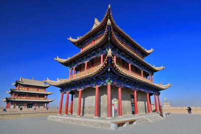 Low angle view of temple building against clear blue sky