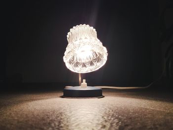 Close-up of illuminated lamp on table at home