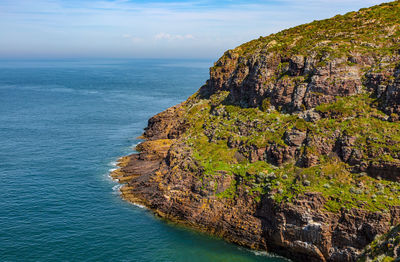 Rock formations by sea against sky