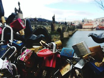 Padlocks on bridge over river in city