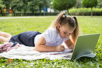 Young woman using laptop at park