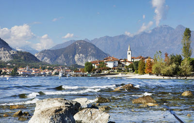 Scenic view of sea by buildings against sky