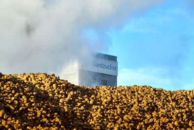 Low angle view of text on rock against sky