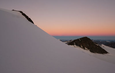 Scenic view of snowcapped mountain against sky during sunset