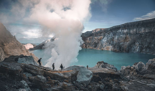 Panoramic view of smoke emitting from volcanic mountain against sky