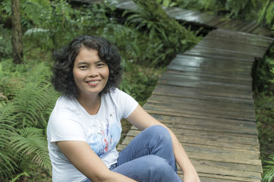 Portrait of smiling woman sitting at park